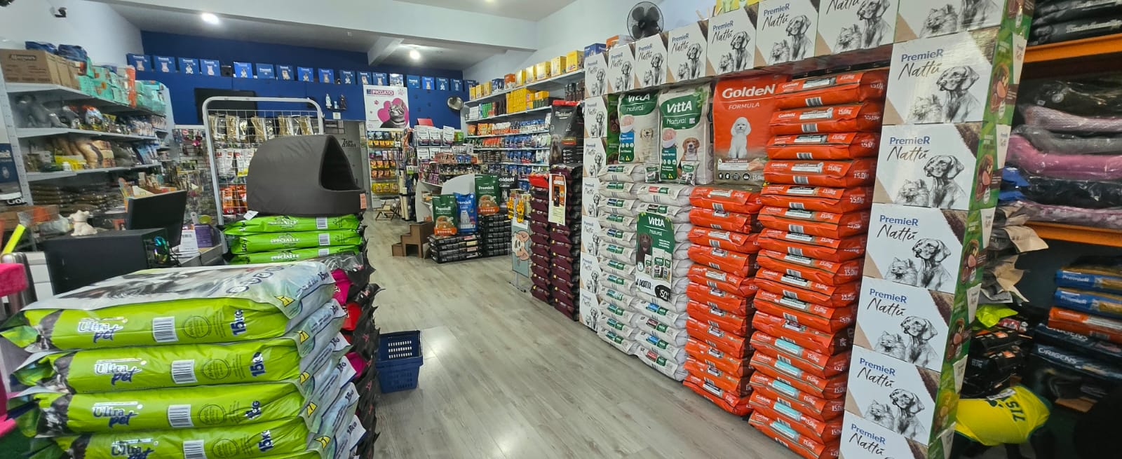Corredor da loja PetCare Queirós com rações e acessórios